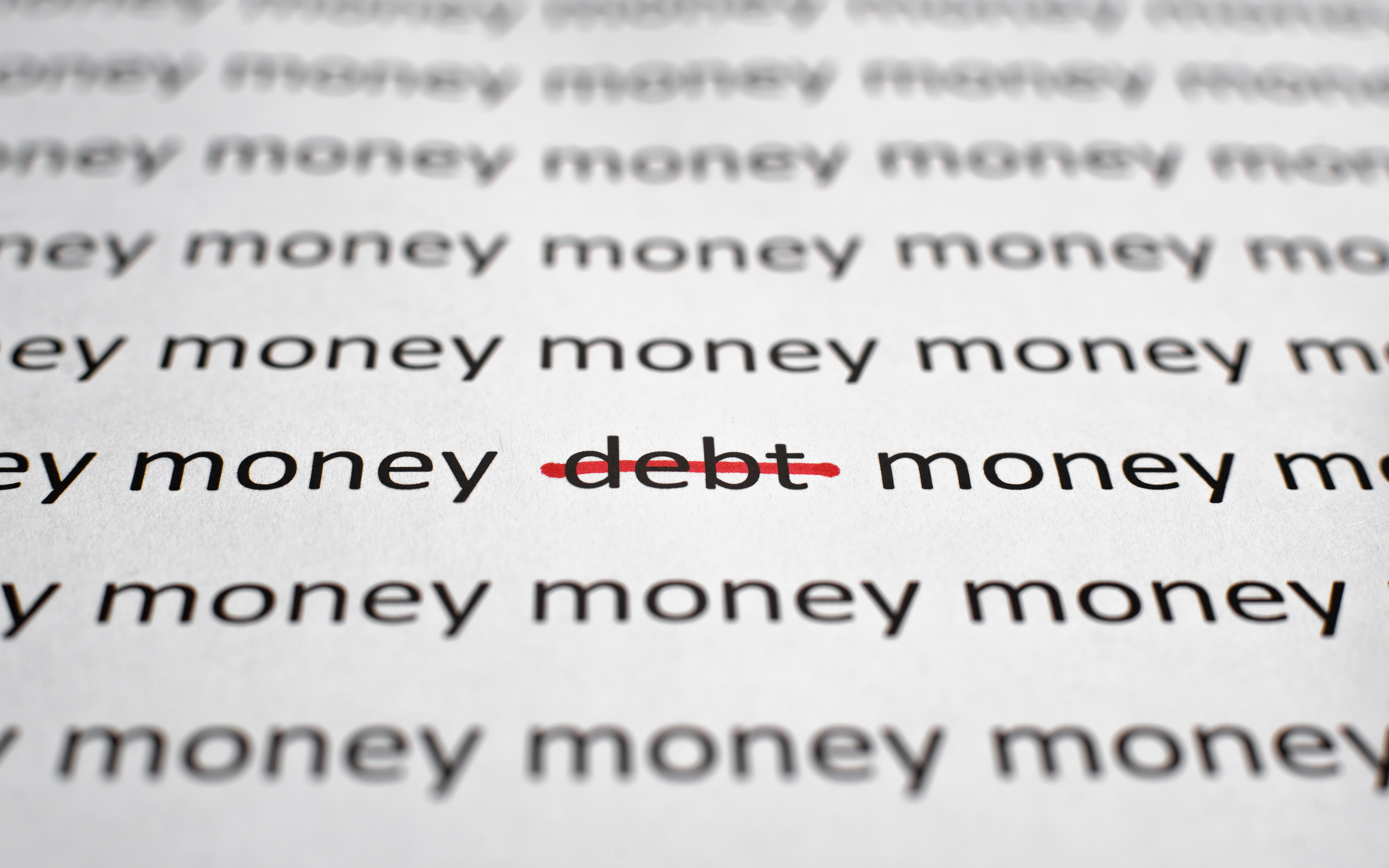 Printed text Money and Debt on white paper, close-up. Financial problems, economics and business